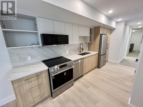 A kitchen with wooden cabinets and a marble countertop.