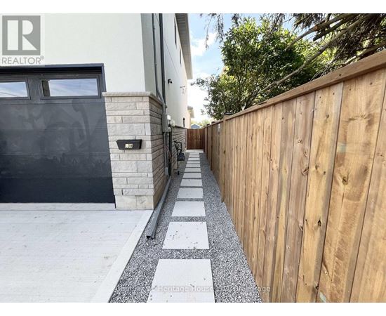 A wooden fence runs along the side of a house.
