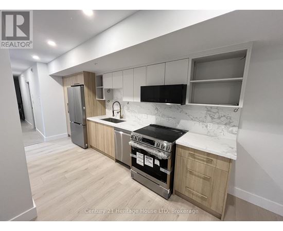 A kitchen with a stove top oven and a refrigerator.