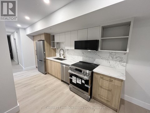 A kitchen with a stove top oven and a refrigerator.
