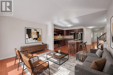 A living room with a grey couch, a coffee table, and a painting on the wall.
