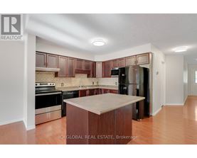 A kitchen with wooden cabinets and a black refrigerator.