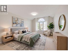 A bedroom with a large bed, a chair, and a painting on the wall.
