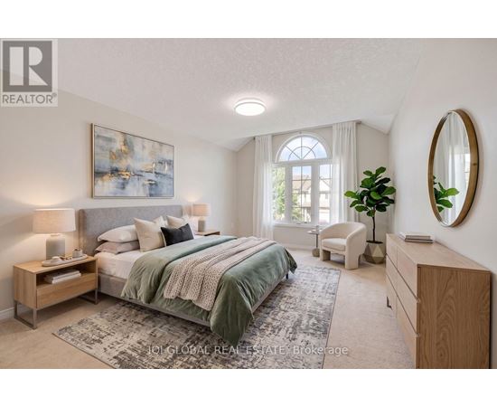 A bedroom with a large bed, a chair, and a painting on the wall.