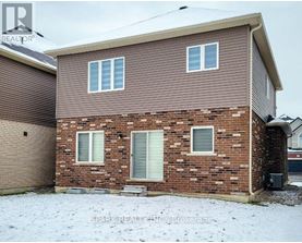 A house with a brown siding and a brick wall with a garage door.