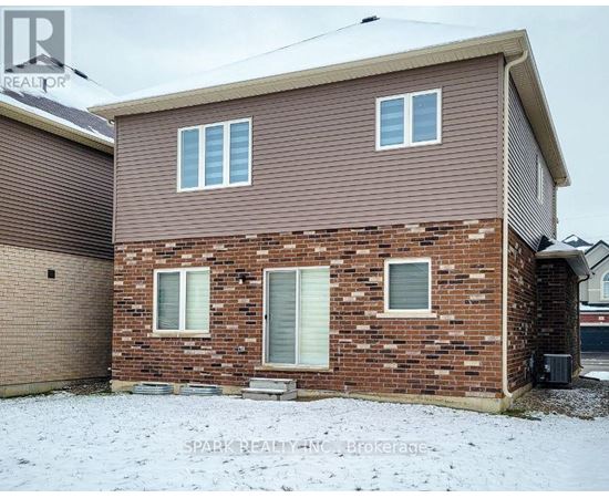 A house with a brown siding and a brick wall with a garage door.