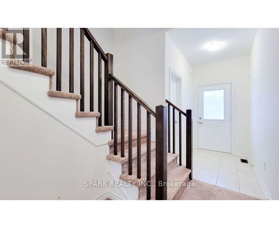 A staircase with a white wall and a door at the top.
