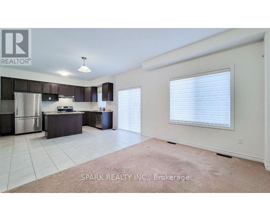 A kitchen with white cabinets and a stainless steel refrigerator.
