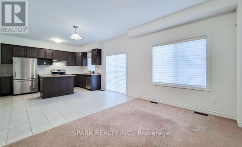 A kitchen with white cabinets and a stainless steel refrigerator.