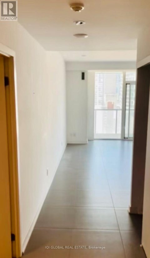 A long hallway with white walls and tile flooring.