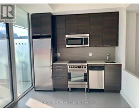 A modern kitchen with stainless steel appliances and wooden cabinets.