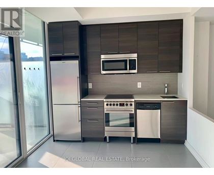 A modern kitchen with stainless steel appliances and wooden cabinets.