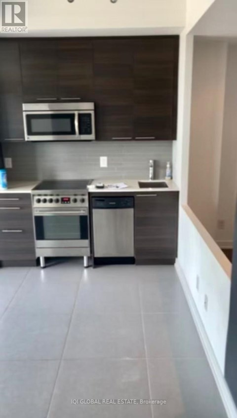 A modern kitchen with a stainless steel oven and microwave.