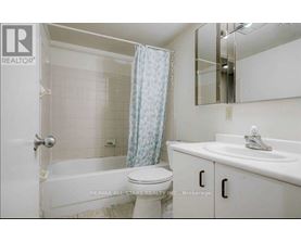 A white bathroom with a toilet, sink, and bathtub.