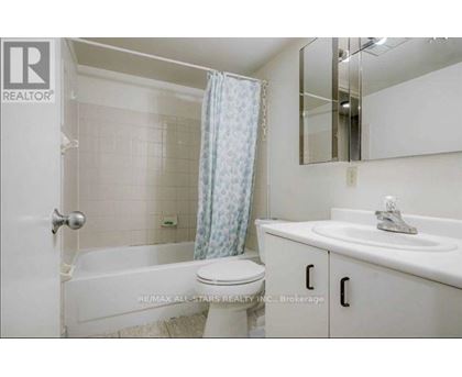 A white bathroom with a toilet, sink, and bathtub.