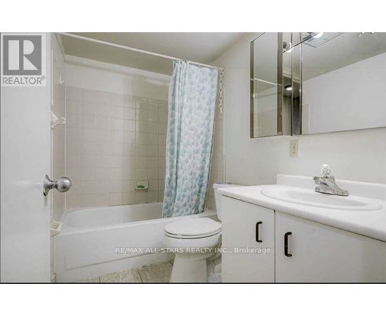 A white bathroom with a toilet, sink, and bathtub.