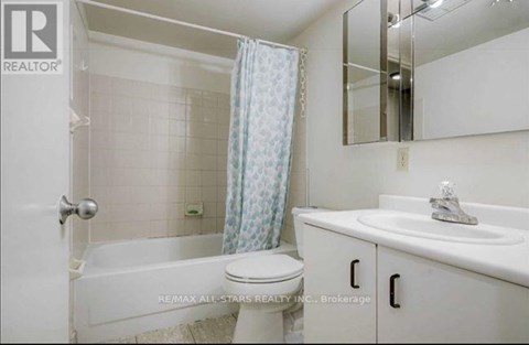 A white bathroom with a toilet, sink, and bathtub.