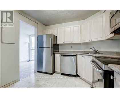 A kitchen with white cabinets and a stainless steel refrigerator.