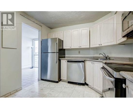 A kitchen with white cabinets and a stainless steel refrigerator.