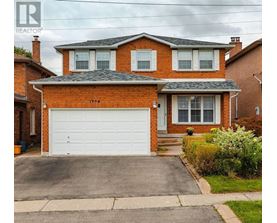 A red brick house with a white garage door.