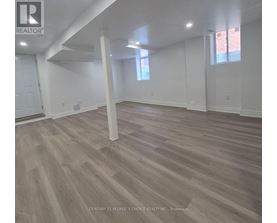 A room with wooden flooring and white walls.