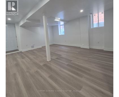A room with wooden flooring and white walls.