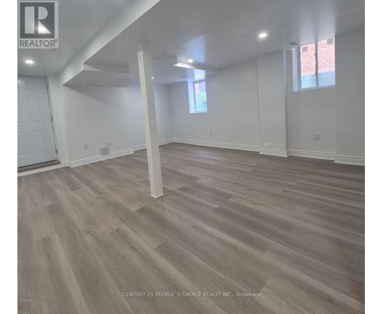 A room with wooden flooring and white walls.