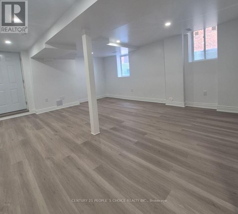 A room with wooden flooring and white walls.