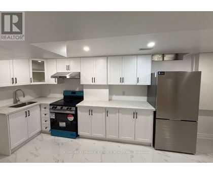 A kitchen with white cabinets and a stove top oven.
