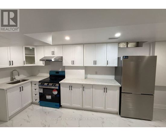 A kitchen with white cabinets and a stove top oven.