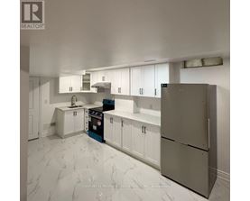 A kitchen with white cabinets and a marble floor.