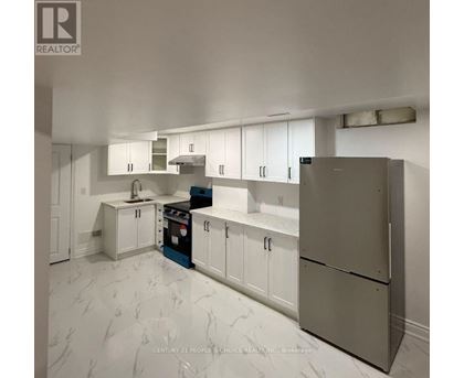 A kitchen with white cabinets and a marble floor.