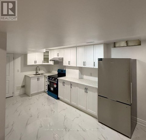 A kitchen with white cabinets and a marble floor.