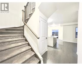 A staircase with a wooden banister leads to a bright room with a window.