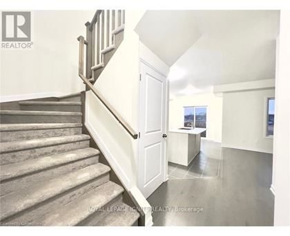 A staircase with a wooden banister leads to a bright room with a window.