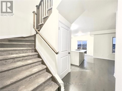 A staircase with a wooden banister leads to a bright room with a window.