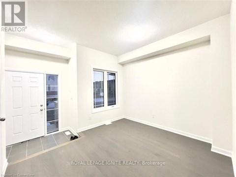 A white door is on the left and a window with a view of a building is on the right.