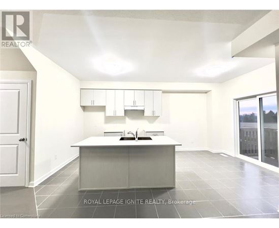 A spacious kitchen with white cabinets and a large island.