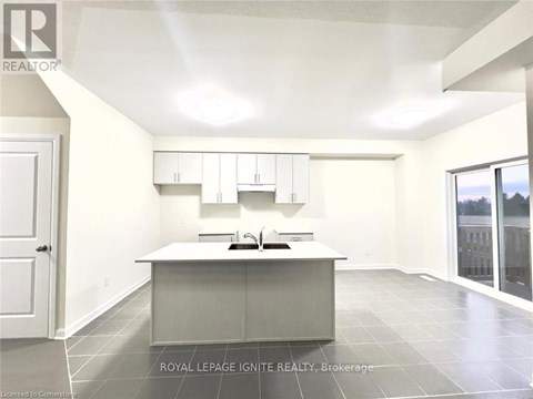 A spacious kitchen with white cabinets and a large island.