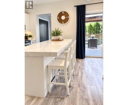 A kitchen with a white counter top and bar stools.