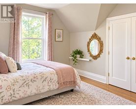 A bedroom with a floral bedspread and a mirror on the wall.