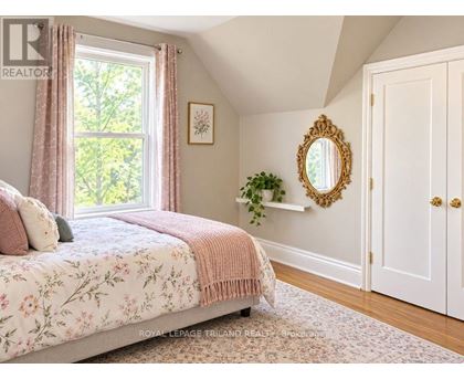 A bedroom with a floral bedspread and a mirror on the wall.