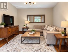 A living room with a grey couch, a wooden coffee table, and a flat screen TV.