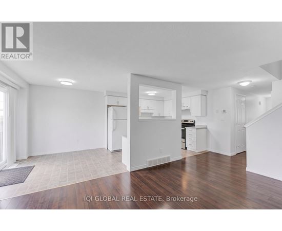 A white interior of a house with a kitchen and stairs.