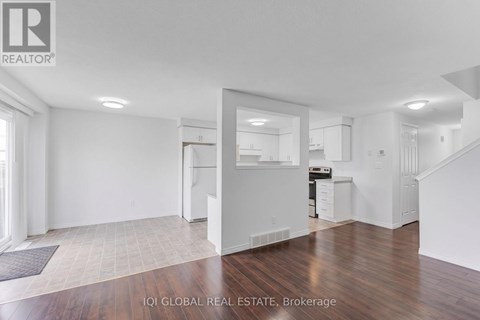 A white interior of a house with a kitchen and stairs.