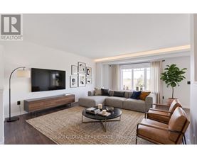 A living room with a couch, chairs, and a television.