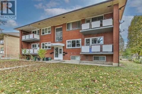 A red brick building with a balcony and a door.