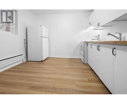 A kitchen with white cabinets and a white fridge.