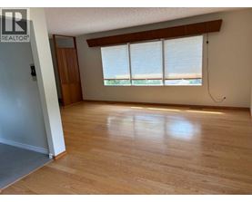 A room with wooden floors and a window with blinds.