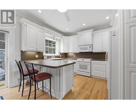 A kitchen with white cabinets and a wooden floor.